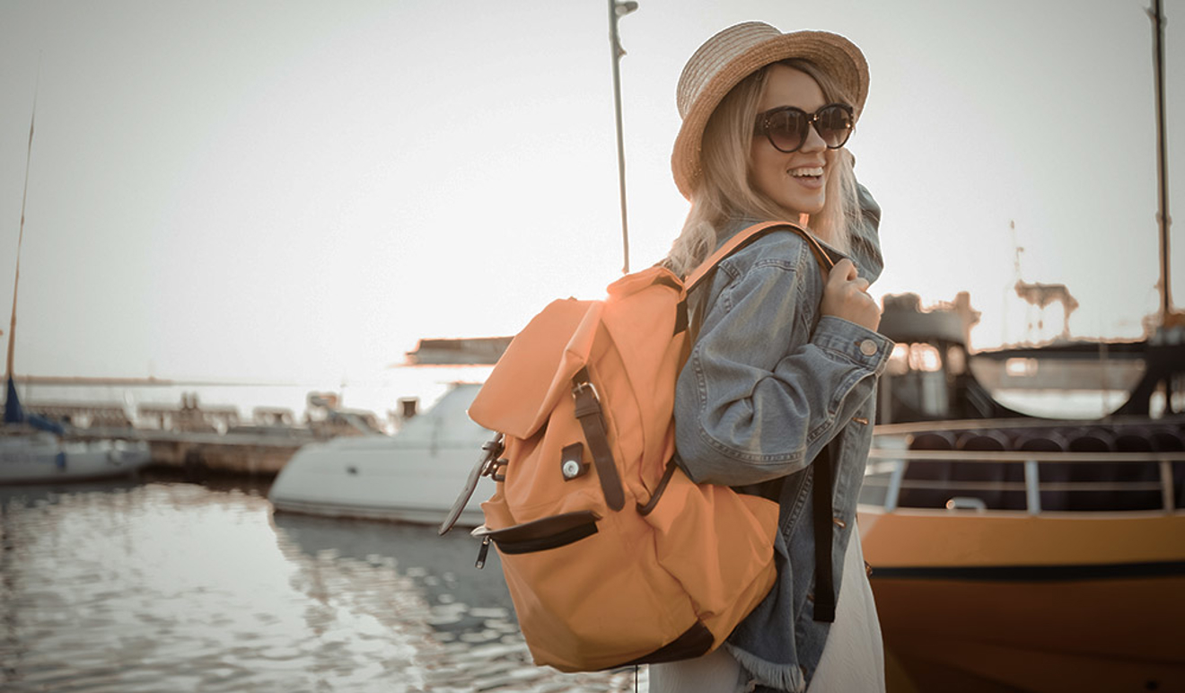 woman smiling, whilst holding a large rucksack on her back