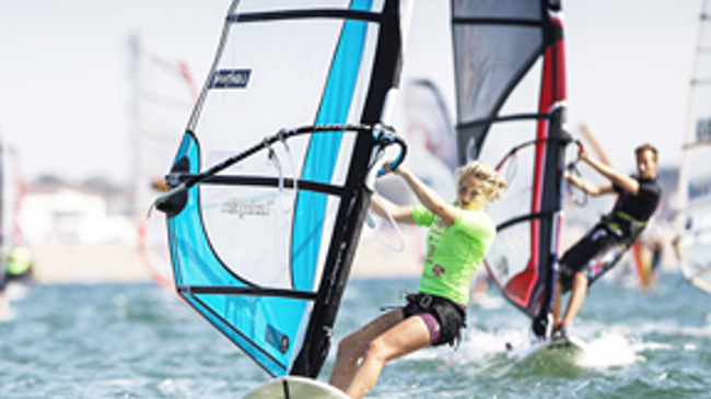 	An image showing two people windsurfing on the water.