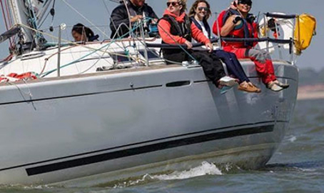 Sailors sat on the edge of a yacht