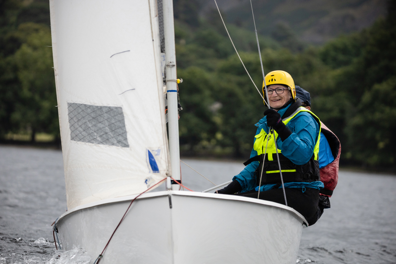 Woman sailing a dinghy looking happy
