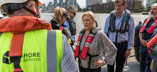 Baroness Vere is on a boat talking to members of staff from the RYA