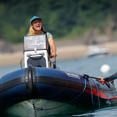 Person on dinghy next to a person on a RIB