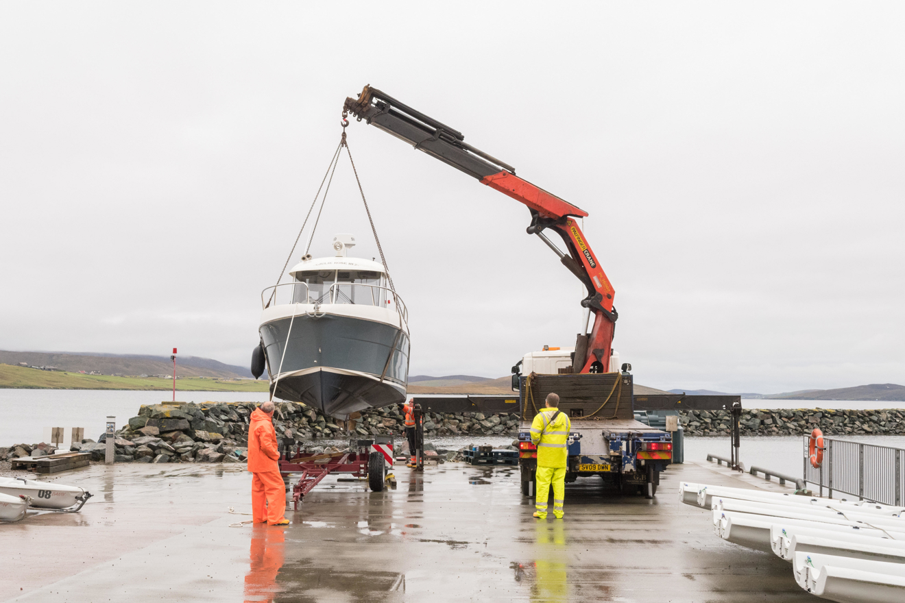 A boat being lifted into the air by a crane