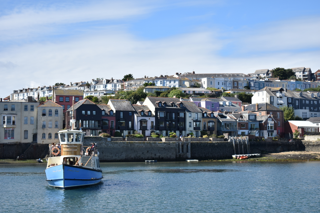 Wide shot of ferry boat with Cornish fishing village Falmouth in the background.