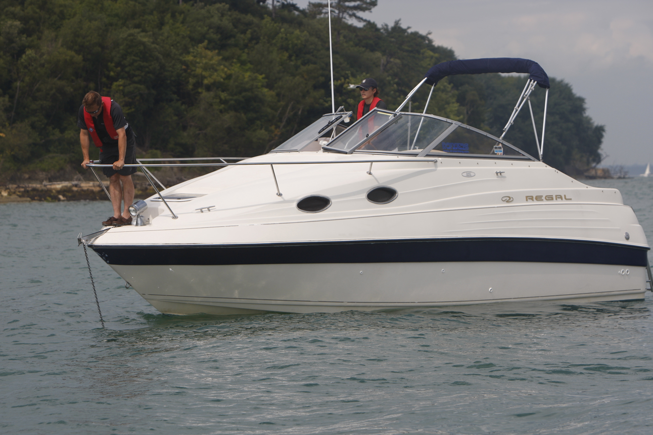 Man stood over bow trying to anchor with care