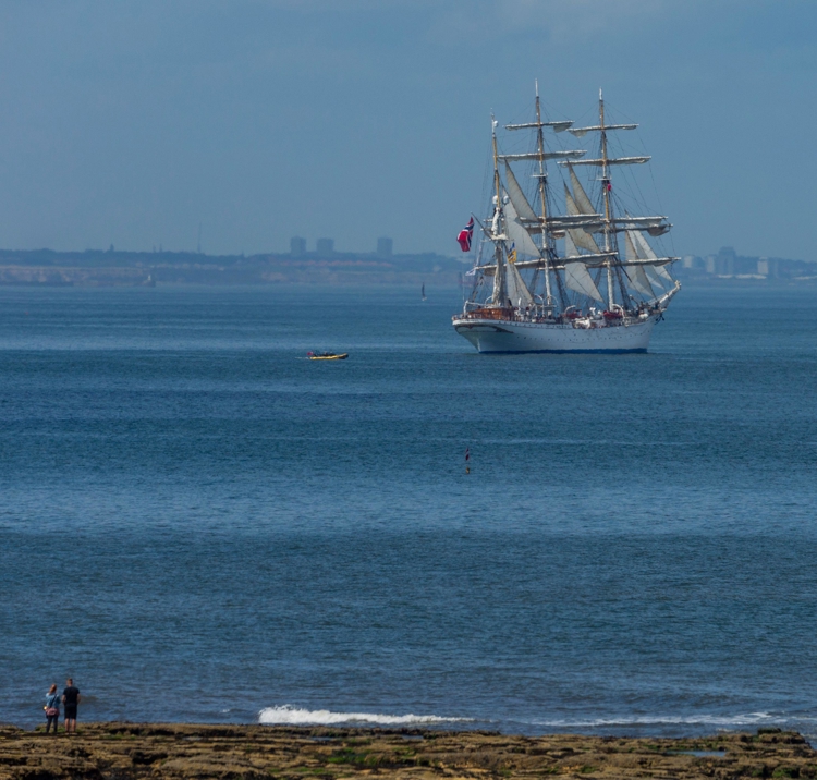 Boat sailing in the distance through blue waters