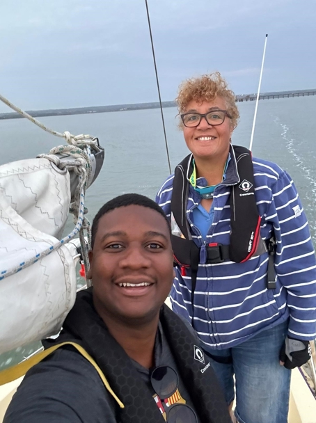 Tinu sailing a keelboat with a friend off the coast