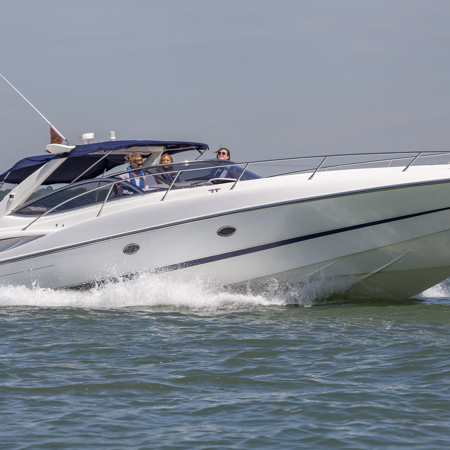 Motor cruiser speeding through the ocean with numerous people onboard