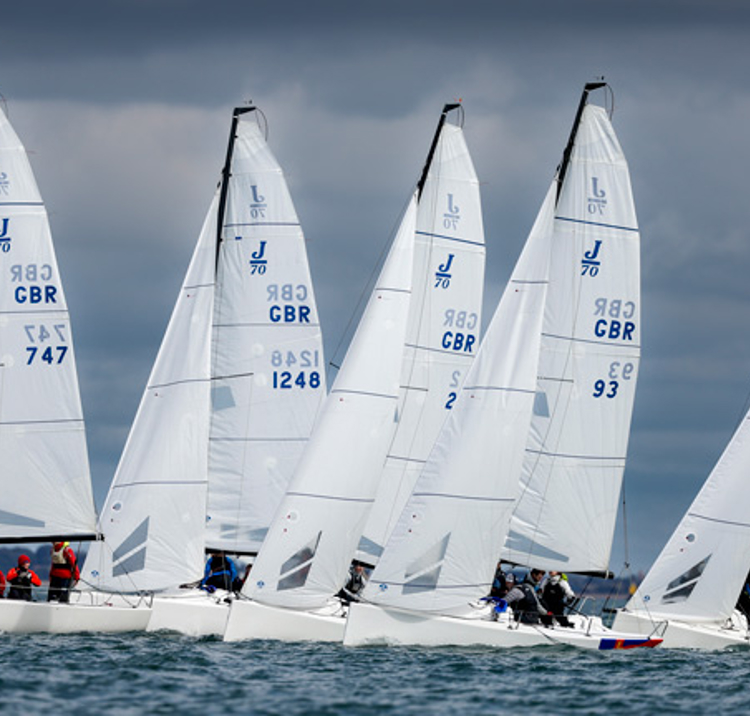 Multiple dinghies sailing along the horizon