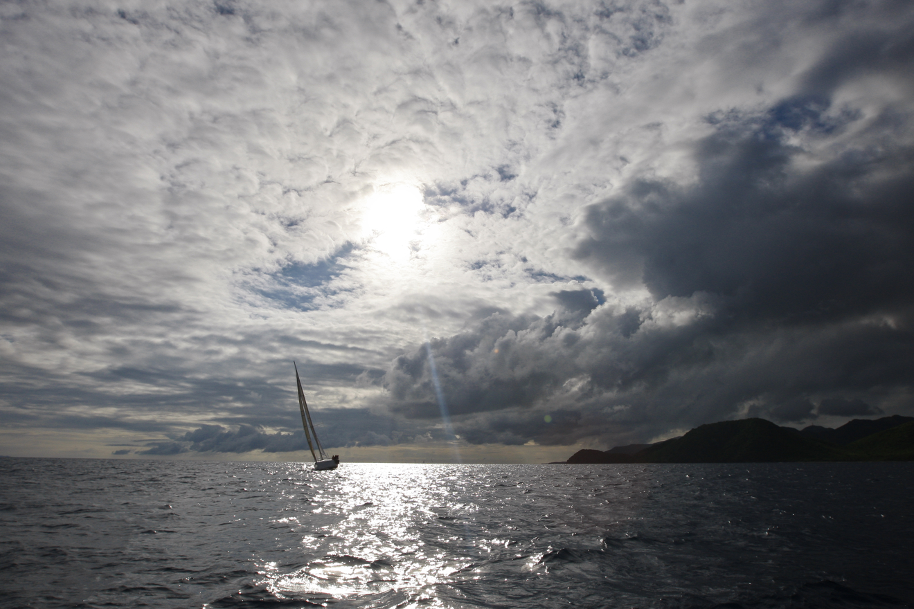 Yacht sailing along horizon in the distance 