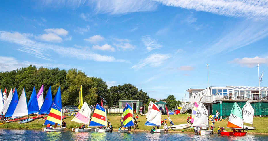 An image of boats with people waiting by the shore