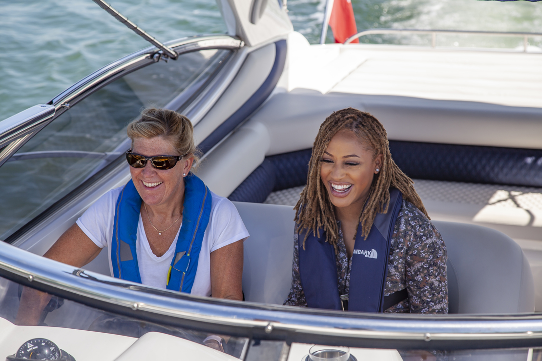 A close up of two smiling women in a motorboat