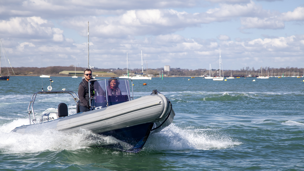 An image of a couple sailing on a high speed boat