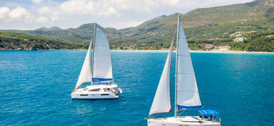 An image of two boats by the river sailing