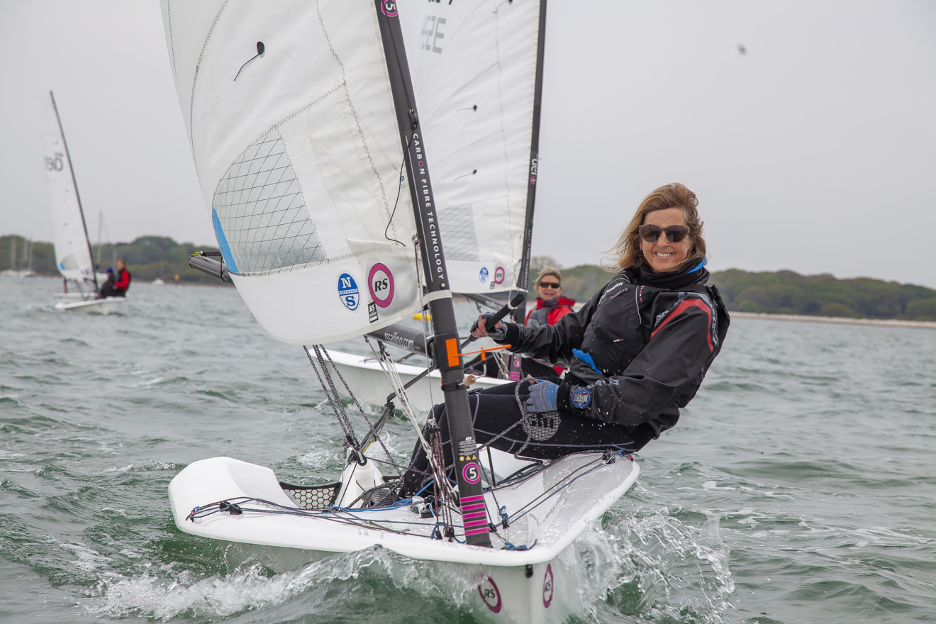 Woman on a dinghy looking to the camera and smiling