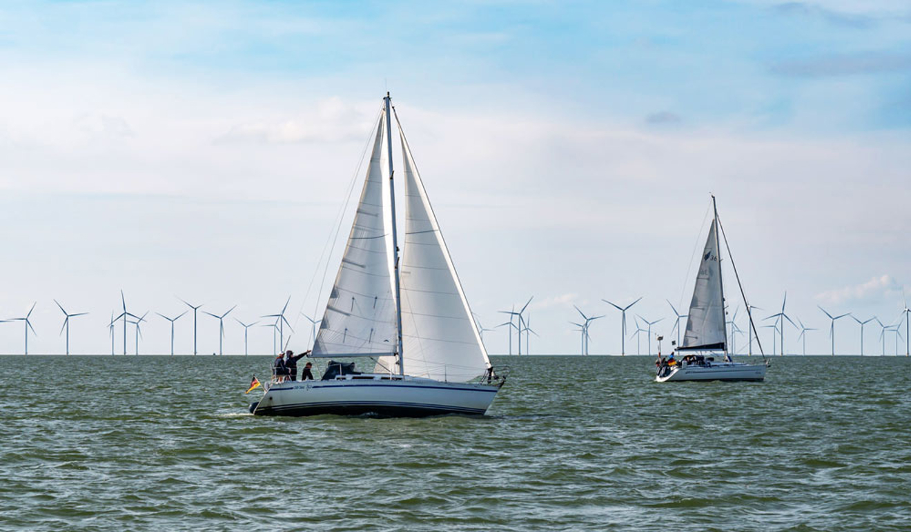 yacht sailing through offshore windfarm