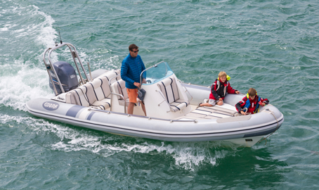Overhead shot of man on powerboat with child passengers