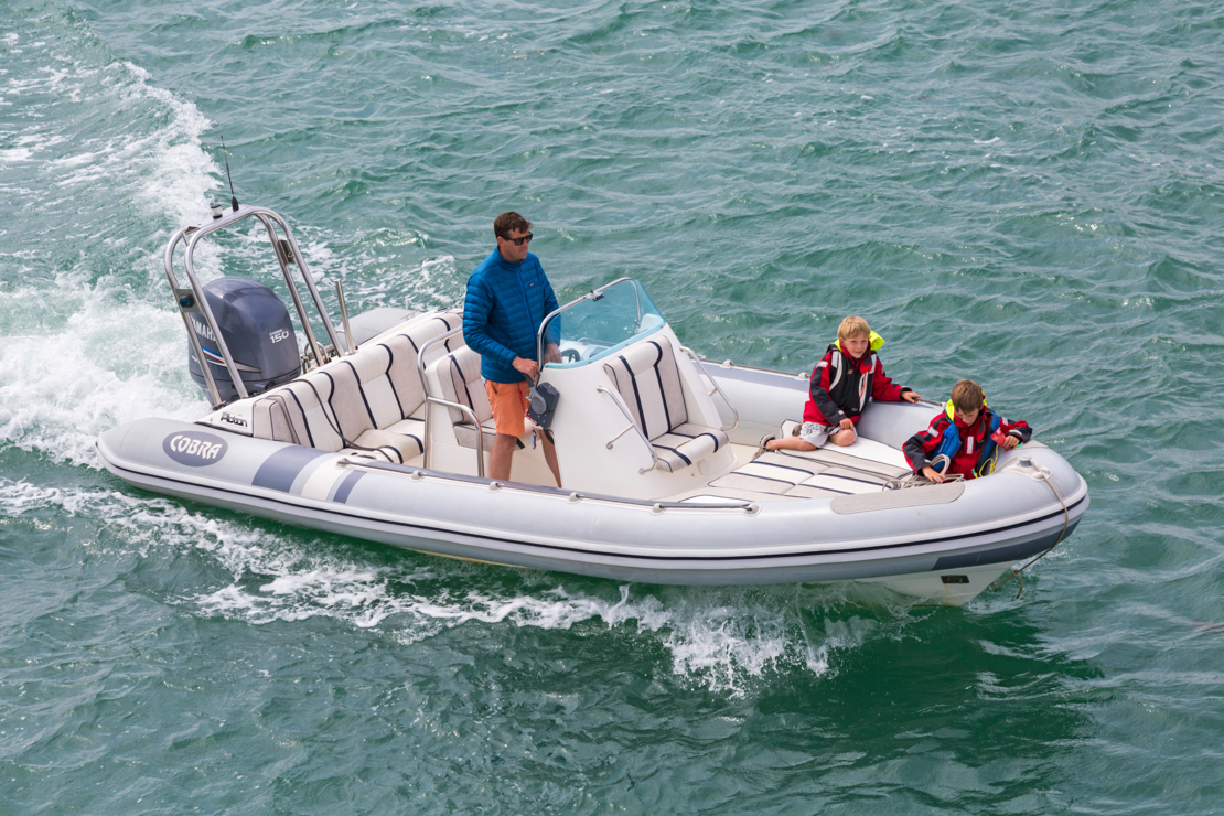 Overhead shot of man on powerboat with child passengers