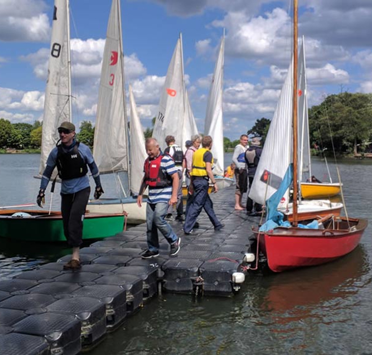 Man on deck with moored dinghies