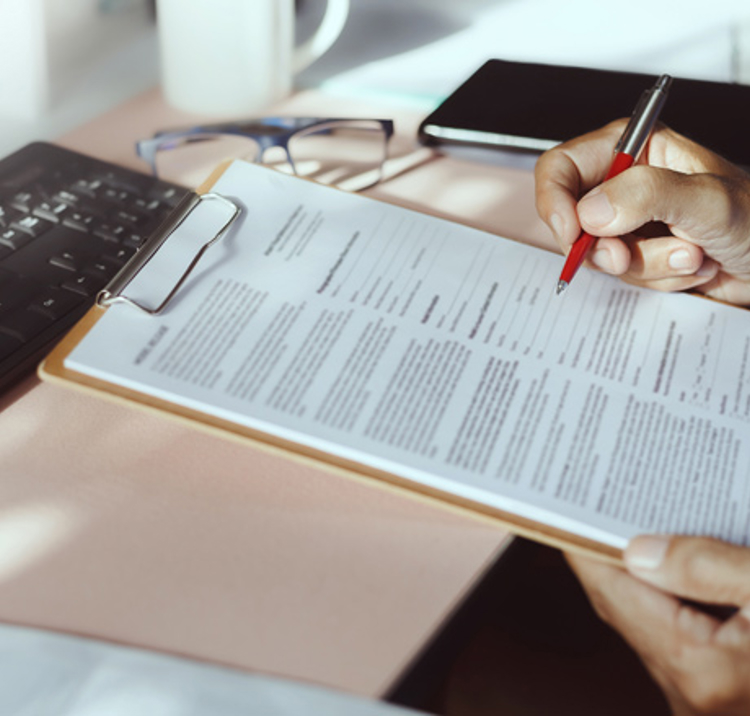 person signing form on clipboard