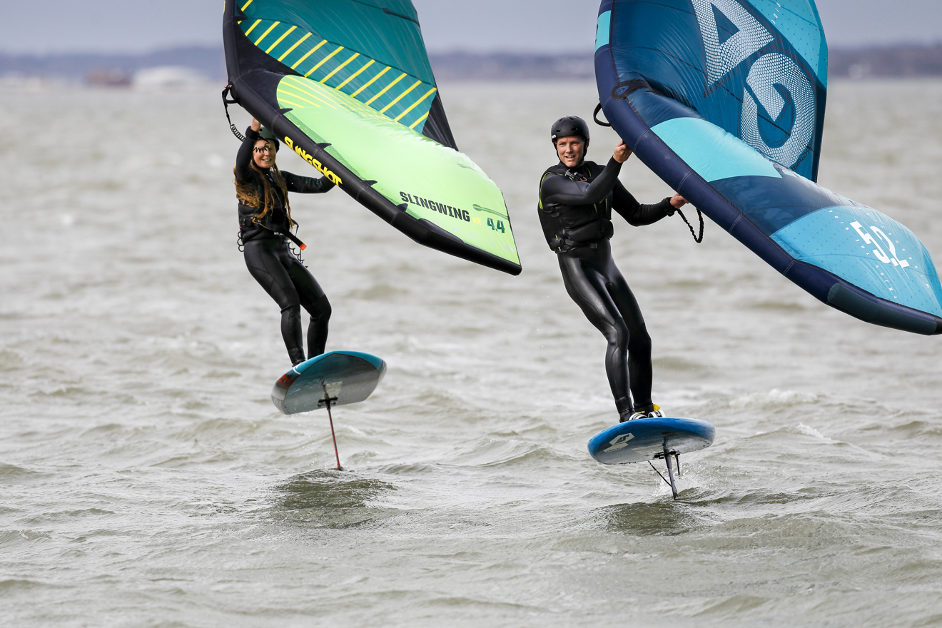 two people wing foiling on the open water