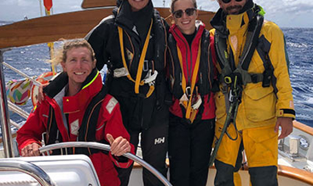 Sailors stood at the bow of boat smiling