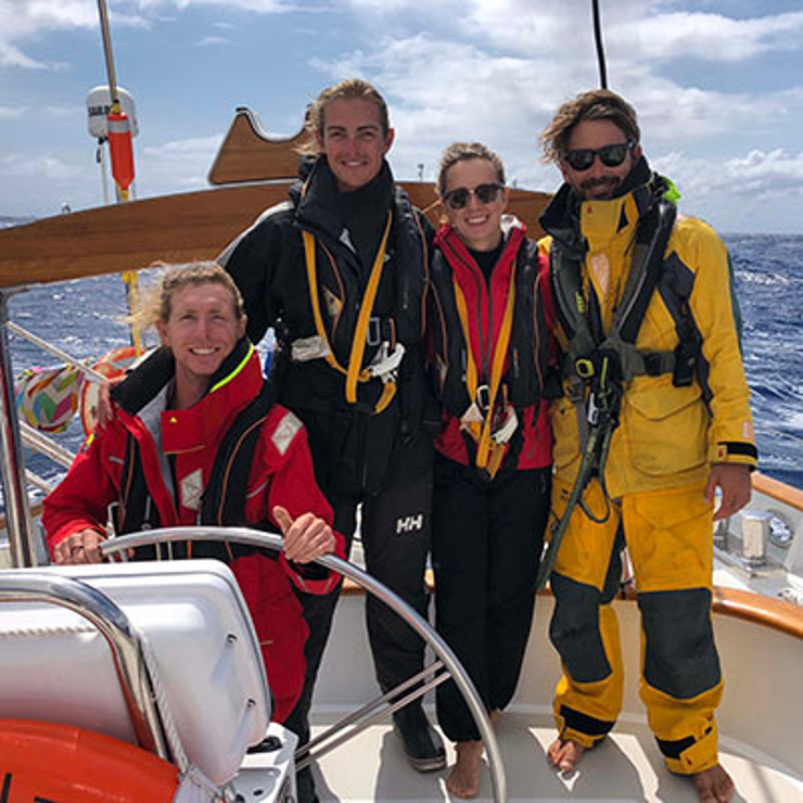 Sailors stood at the bow of boat smiling
