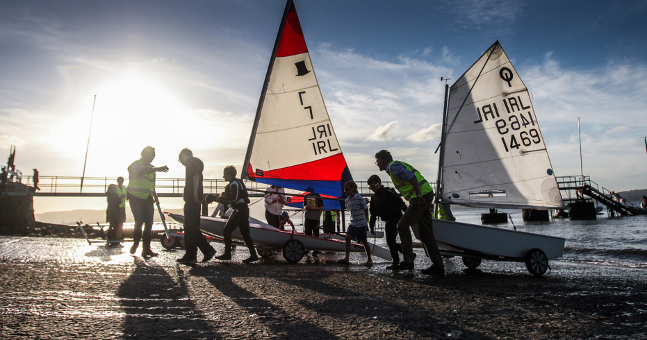 Instructors and trainees wheeling dinghies out of water