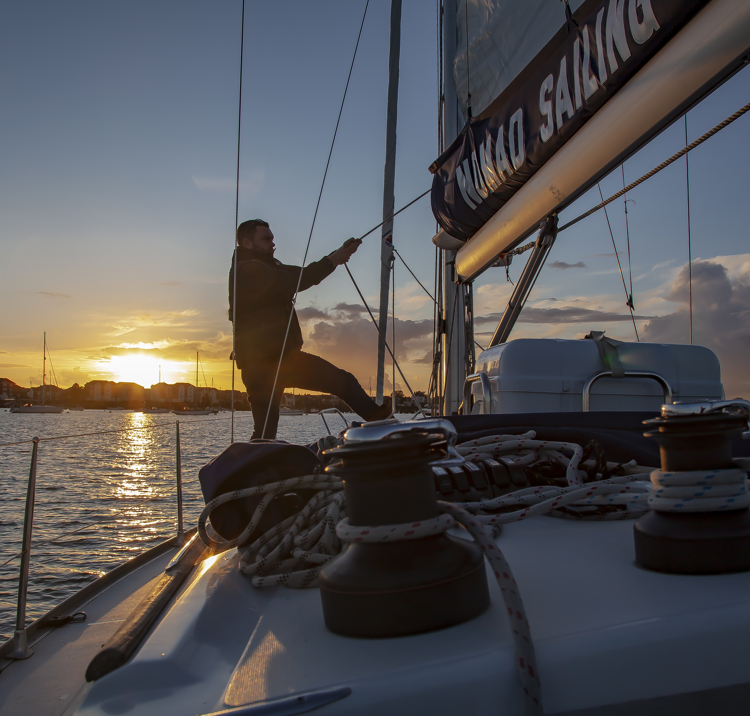 Adjusting sails at sunset