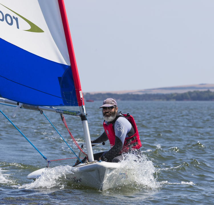 man on small boat sailing course