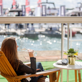 Woman in deckchair drinking by the water
