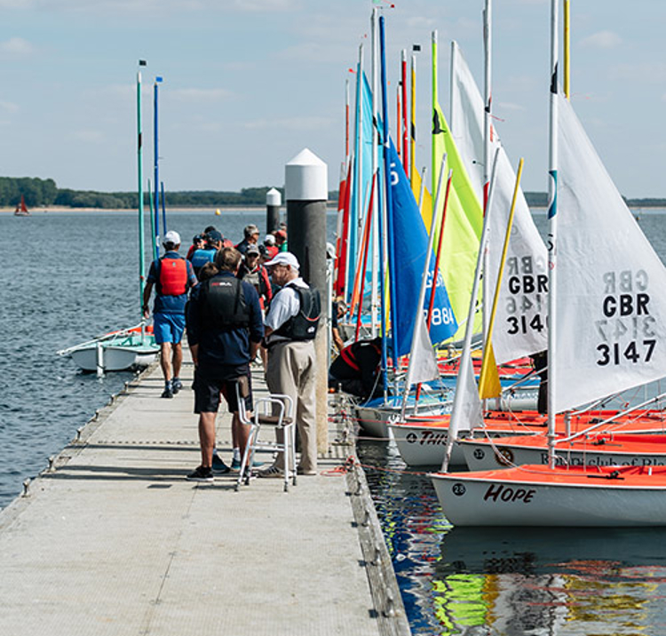 Children walking along a dock to their boats