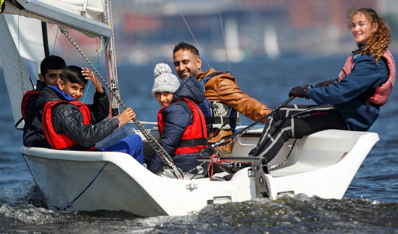 Happy family sailing in a dinghy