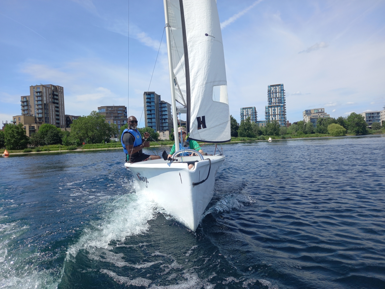 two man sailing a dinghy on the water