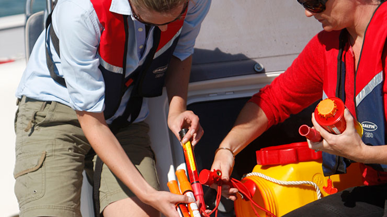 Two sailors packing the contents of their grab bag