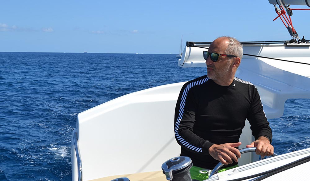 Gentleman on a yacht steering looking out on to the ocean
